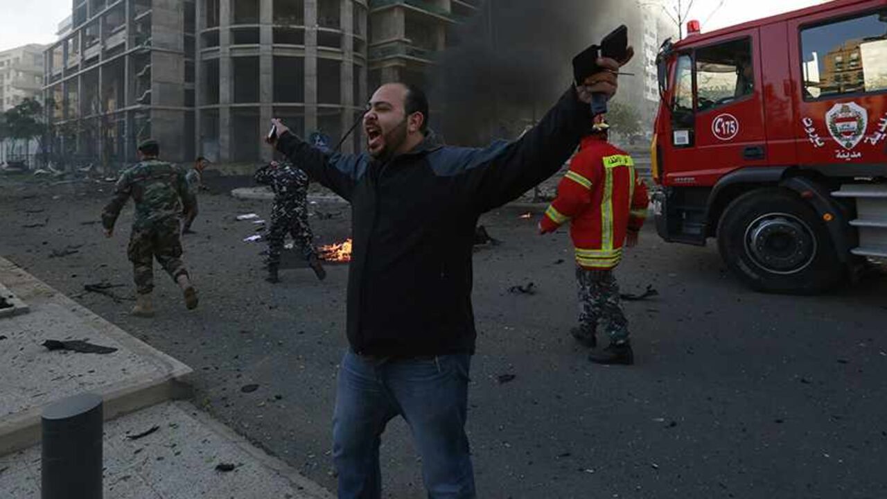 A security personnel shouts as smoke rises from the site of an explosion in Beirut's downtown area December 27, 2013. Former Lebanese minister Mohamad Chatah, who opposed Syrian President Bashar al-Assad, was killed in an explosion that targeted his convoy in Beirut on Friday along with at least four other people, security sources said.  REUTERS/Jamal Saidi (LEBANON  - Tags: CIVIL UNREST POLITICS) - RTX16URP