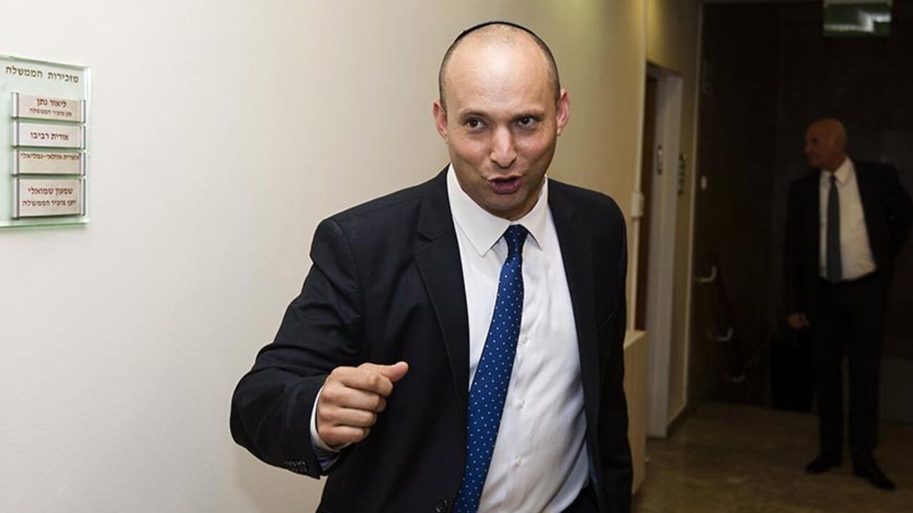 Israel's new Economics and Trade Minister Naftali Bennett, leader of the Jewish Home party, gestures as he arrives to attend the first cabinet meeting after the swearing-in of the new Israeli government in Jerusalem on March 18, 2013. A new Israeli governing coalition with a strong showing of pro-settlement hardliners formally took office after confirmation by parliament days before a landmark US presidential visit. AFP PHOTO/POOL/DAVID VAAKNIN        (Photo credit should read DAVID VAAKNIN/AFP/Getty Images
