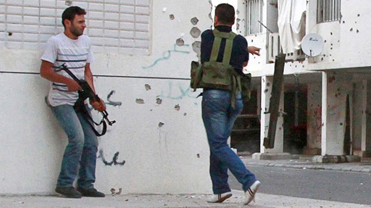 A Lebanese Sunni gunman (R) is injured by gunfire while trying to fire a rocket towards the Jabal Mohsen district, home to the minority Alawite sect, during clashes in Lebanon's northern port city of Tripoli, June 2, 2012. Clashes erupted between supporters and opponents of Syrian President Bashar al-Assad in neighbouring Lebanon's northern port city of Tripoli on Saturday, killing eight people and wounding 40, residents and a doctor said. REUTERS/Omar Ibrahim   (LEBANON - Tags: POLITICS CIVIL UNREST TPX IM