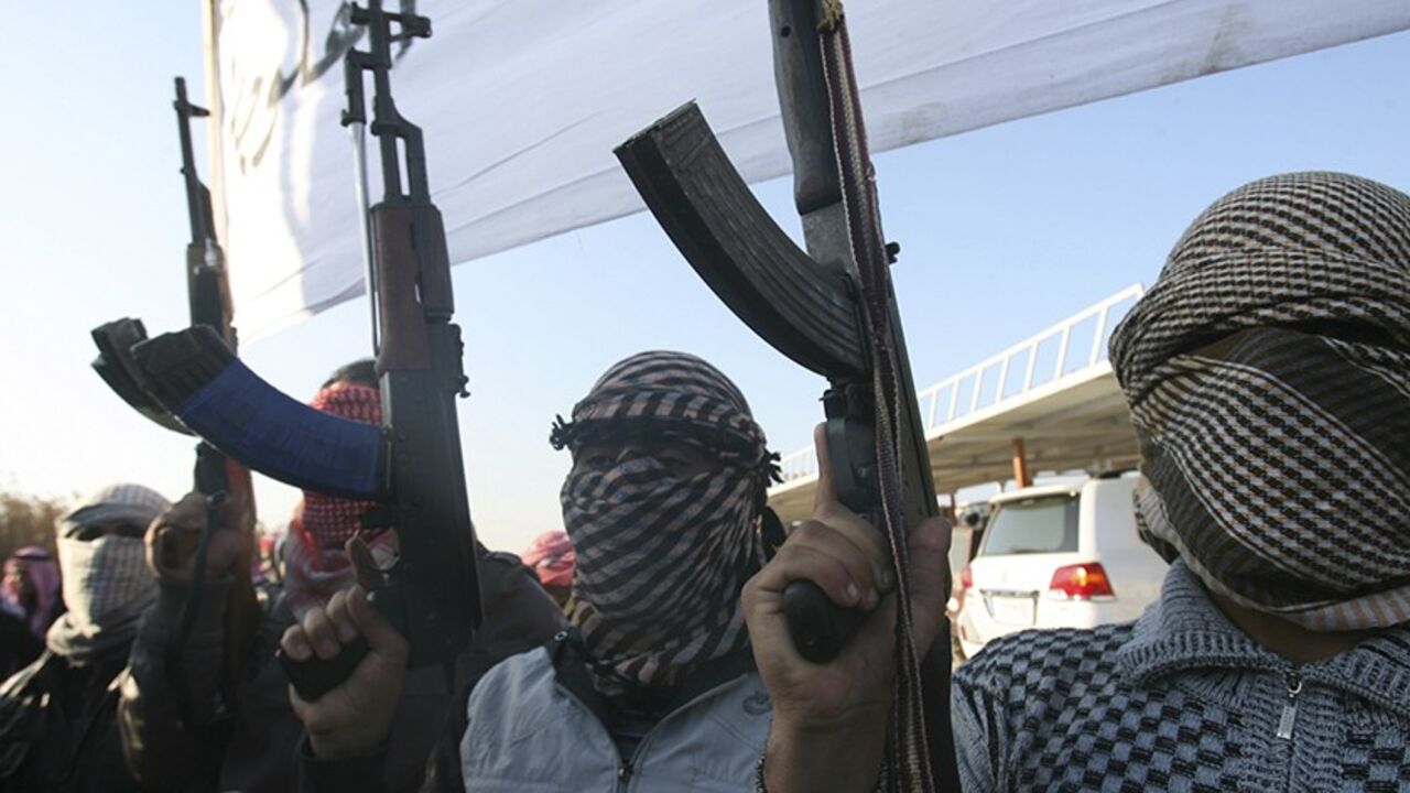 Masked Sunni gunmen chant slogans during a protest against Iraq's Shiite-led government, demanding that the Iraqi army not try to enter the city, in Falluja, 50 km (31 miles) west of Baghdad January 7, 2014. The Iraqi army deployed tanks and artillery around Falluja on Tuesday, security officials said, as local leaders in the besieged city urged al Qaeda-linked militants to leave in order to avert an impending military assault. Many in Iraq's once dominant Sunni Muslim minority, the main group in Anbar, sha