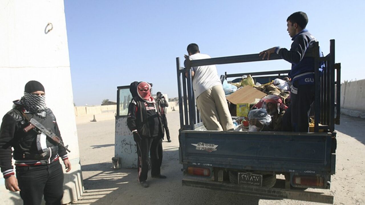 Iraqi Sunni gunmen stand guard as civilians flee their homes, at a checkpoint in the city of Falluja, 50 km (31 miles) west of Baghdad January 8, 2014. Iraqi Prime Minister Nuri al-Maliki vowed to eradicate al Qaeda in Iraq and predicted victory as his army prepared to launch a major assault against the Sunni Islamist militants who have taken over parts of the city of Falluja. Fighters from the al Qaeda affiliated Islamic State of Iraq and the Levant (ISIL), which is also active across the border in Syria, 