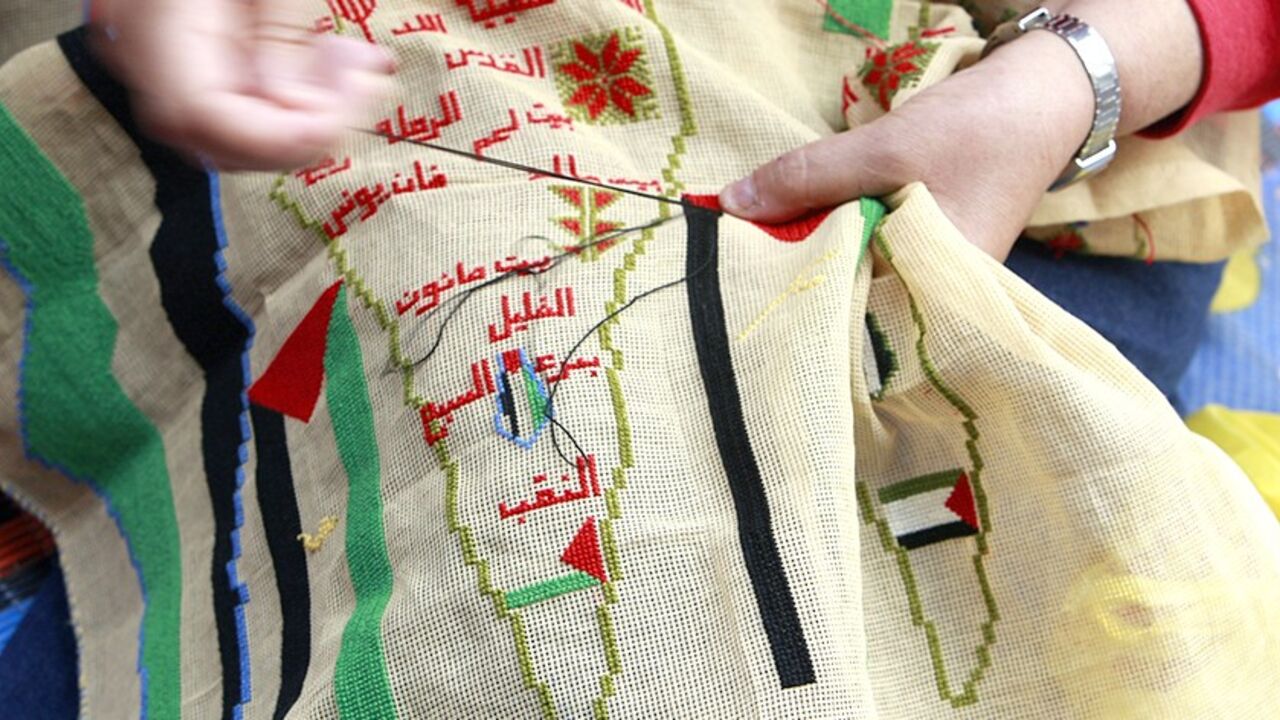 A Palestinian woman embroiders a map of Palestine to mark the 61st anniversary of Nakba at the Burj al-Barajneh refugee camp in Beirut May 15, 2009. Palestinians mark Nakba as a day of mourning for the establishment of Israel in 1948 after which an Arab-Israeli war brought the displacement of hundreds of thousands of Palestinians. REUTERS/Jamal Saidi   (LEBANON ANNIVERSARY POLITICS) - RTXH51I