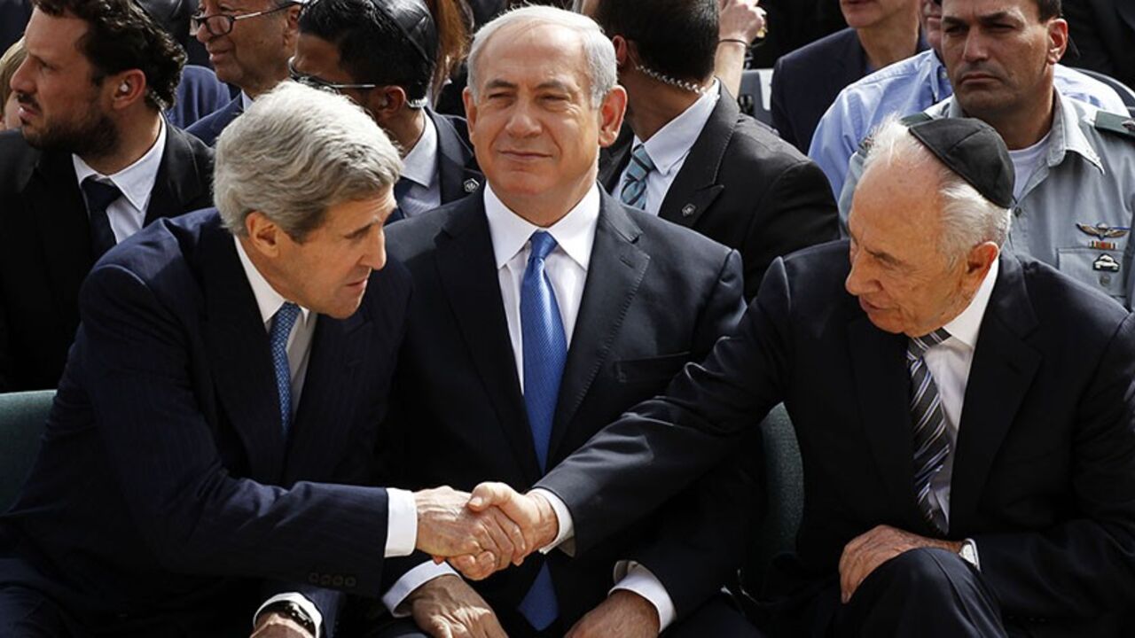 Israeli President Shimon Peres (R) shakes hands with U.S. Secretary of State John Kerry (L) as Prime Minister Benjamin Netanyahu sits in between them during a ceremony marking Israel's annual day of Holocaust remembrance, at Yad Vashem in Jerusalem April 8, 2013. Israel on Monday commemorates the six million Jews killed by the Nazis in the Holocaust during World War Two. 
REUTERS/Gali Tibbon/Pool (JERUSALEM - Tags: POLITICS ANNIVERSARY CONFLICT) - RTXYDCO