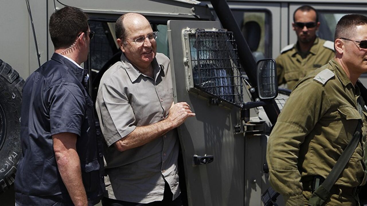 Israeli Defense Minister Moshe Yaalon (2nd L) gets out of a military jeep during a visit to an army base near Kibbutz Kissufim outside the central Gaza Strip May 7, 2013. Israel played down weekend air strikes close to Damascus reported to have killed dozens of Syrian soldiers, saying they were not aimed at influencing its neighbour's civil war but only at stopping Iranian missiles reaching Lebanese Hezbollah militants. REUTERS/Amir Cohen (ISRAEL - Tags: MILITARY POLITICS) - RTXZDJS