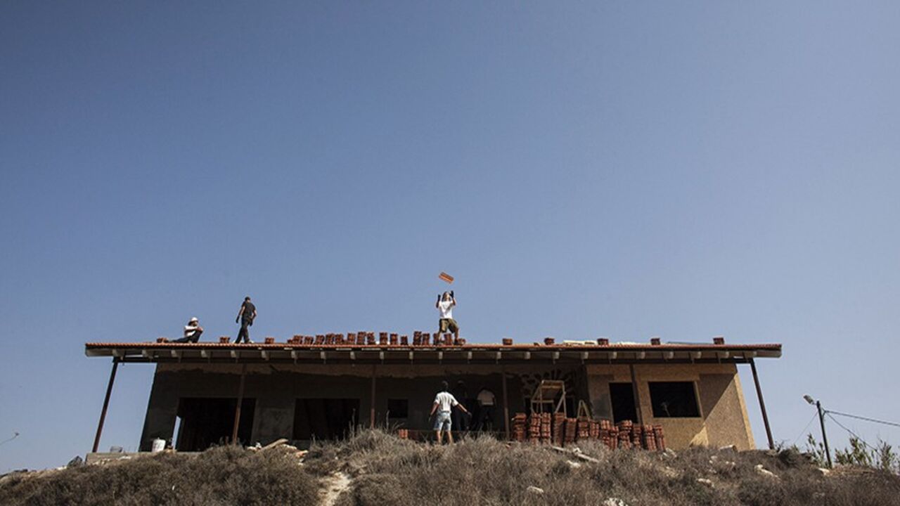 Men work on the roof of a house under construction in the unauthorised Jewish settler outpost of Havat Gilad, south of the West Bank city of Nablus November 5, 2013. Israeli and Palestinian officials said on Tuesday the three-month-old peace talks pressed on them by Washington are going nowhere, painting a grim picture for a visit this week by U.S. Secretary of State John Kerry. Both sides have been airing their frustration over a lack of progress in the U.S.-brokered talks aimed at resolving core issues su