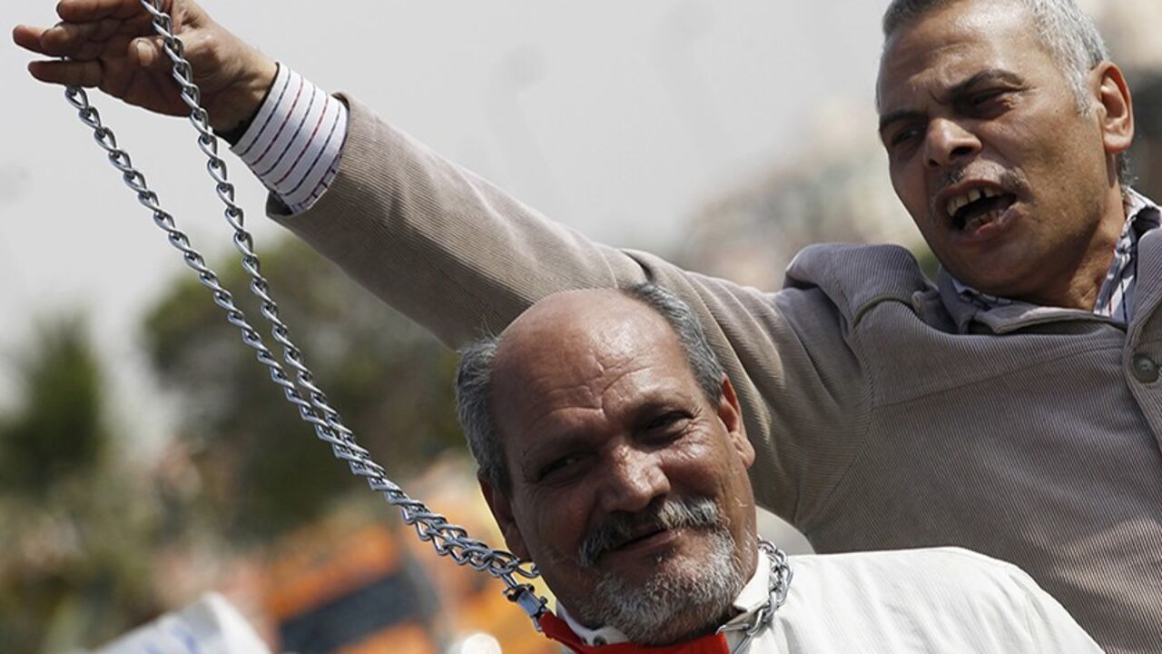 Anti-Mursi supporters of Egypt's army and police, demonstrate with a mock gallows with a person that look like ousted Egyptian President Mohamed Mursi, outside a police academy where the trial of Mursi and members of the Muslim Brotherhood is due to take place, on the outskirts of Cairo February 4, 2014. Mursi and members of the Muslim Brotherhood are charged for inciting the killings of opposition activists during his presidency.   REUTERS/Amr Abdallah Dalsh  (EGYPT - Tags: POLITICS CIVIL UNREST) - RTX187J