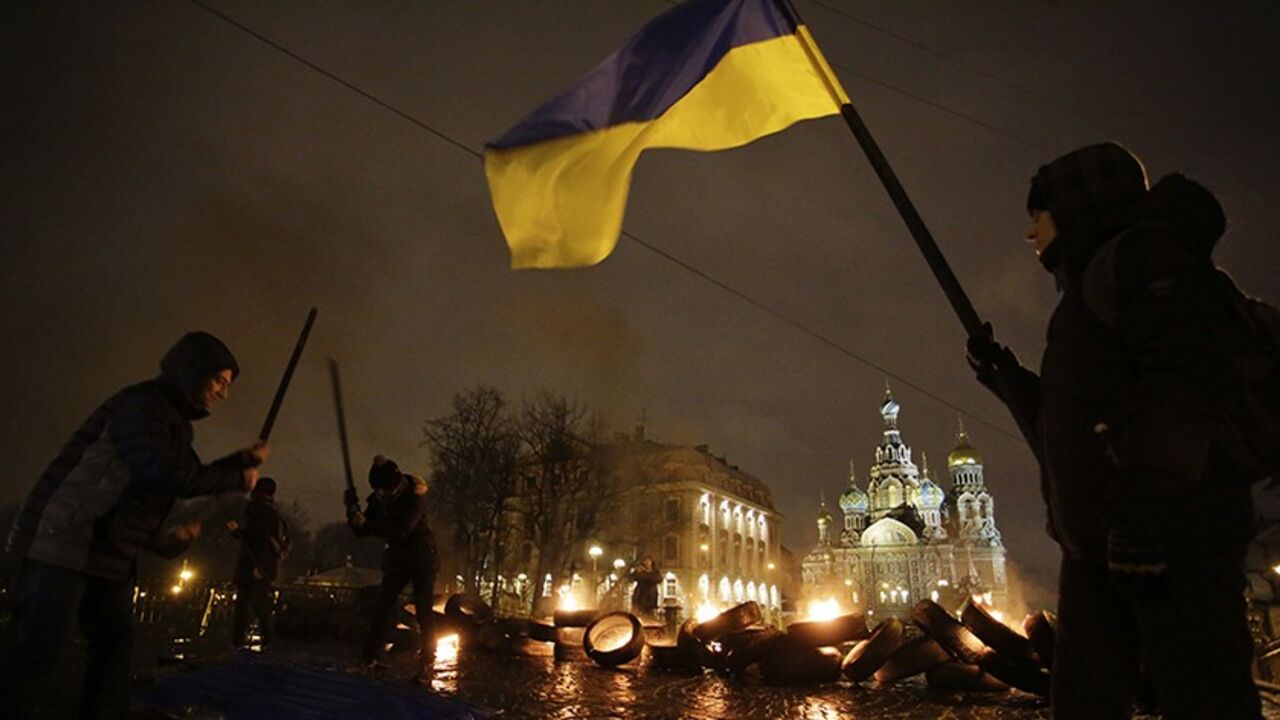 Participants drum with sticks and burn tyres during a performance called "freedom", in support of Ukrainian anti-government protesters who held rallies in Maidan Nezalezhnosti or Independence Square in Kiev, in front of the Church of the Saviour on Spilled Blood in central St. Petersburg February 23, 2014. REUTERS/Maxim Zmeyev (RUSSIA - Tags: POLITICS CIVIL UNREST TPX IMAGES OF THE DAY) - RTX19CK6