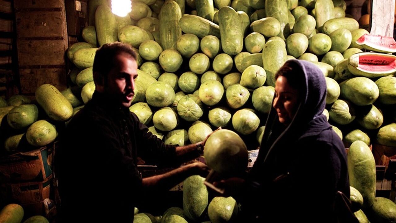 An Iranian woman buys a watermelon in downtown Tehran on December 21, 2013, in preparation for the annual festival of Yalda, an ancient Zoroastrian rite held on the longest night of the year or the beginning of winter. The rite, which marks the victory of Good over Evil, is still celebrated by most Iranians even though Islam replaced Zoroastrianism as the official religion in the seventh century. Iranians traditionally spend Yalda at home with their families, reciting poetry and feasting on fruits and nuts.