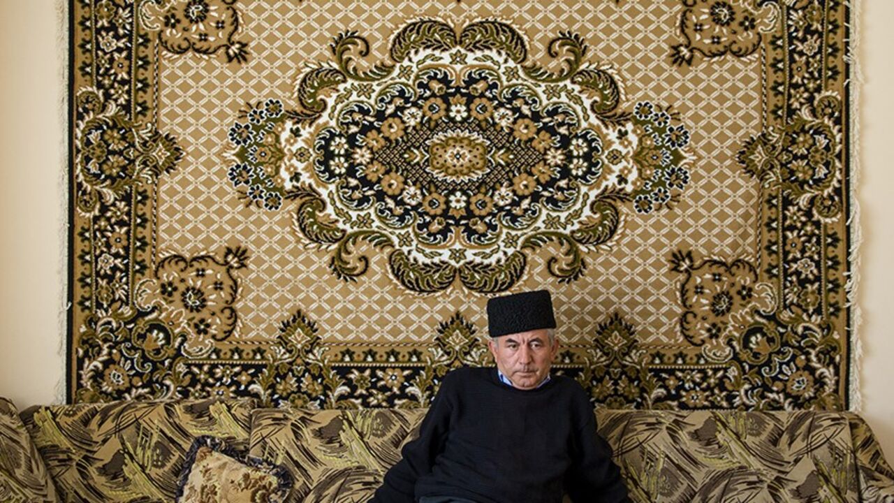 Mustafa Asaba, a regional leader of Crimean Tatars, sits in the living room of a friend's home in Belogorsk near the Crimean capital of Simferopol March 17, 2014. Among the voices drowned out by victory celebrations across Crimea as it voted to leave Ukraine and join Russia were those of the Tatars, a minority group for whom the prospect of a return to Moscow rule brings fear and uncertainty. Picture taken March 17, 2014.  REUTERS/Thomas Peter (UKRAINE  - Tags: POLITICS SOCIETY) - RTR3HIWN