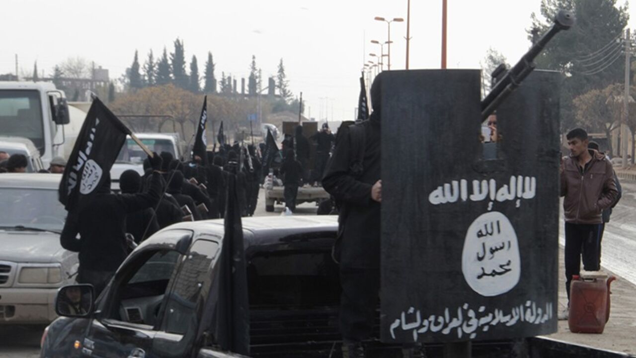 Fighters of the al-Qaeda linked Islamic State of Iraq and the Levant wave flags as they take part in a parade, while a fellow fighter stands on the back of a truck at the Syrian town of Tel Abyad, near the border with Turkey January 2, 2014. Picture taken January 2, 2014.    REUTERS/Yaser Al-Khodor (SYRIA - Tags: POLITICS CIVIL UNREST) - RTX170TT