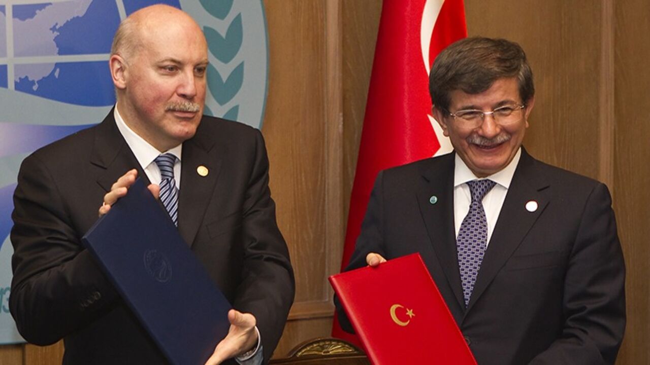 Turkey's Foreign Minister Ahmet Davutoglu (R) and Secretary-General of Shanghai Cooperation Organisation (SCO) Dmitry Mezentsev show signed documents granting Turkey a partner status in SCO, in Almaty April 26, 2013.  REUTERS/Shamil Zhumatov  (KAZAKHSTAN - Tags: POLITICS BUSINESS) - RTXZ0S8