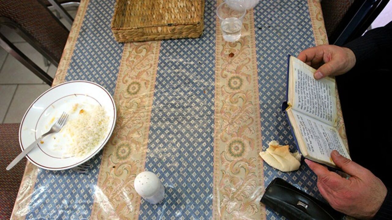 An Israeli man prays after eating lunch in a soup kitchen in Jerusalem March 20, 2006. Growing Israeli poverty, as illustrated by the hundreds of soup kitchens opening up nationwide in the last few years, is a prominent issue in Israel's campaign for a March 28 parliamentary election.  REUTERS/Yonathan Weitzman - RTR17FHL