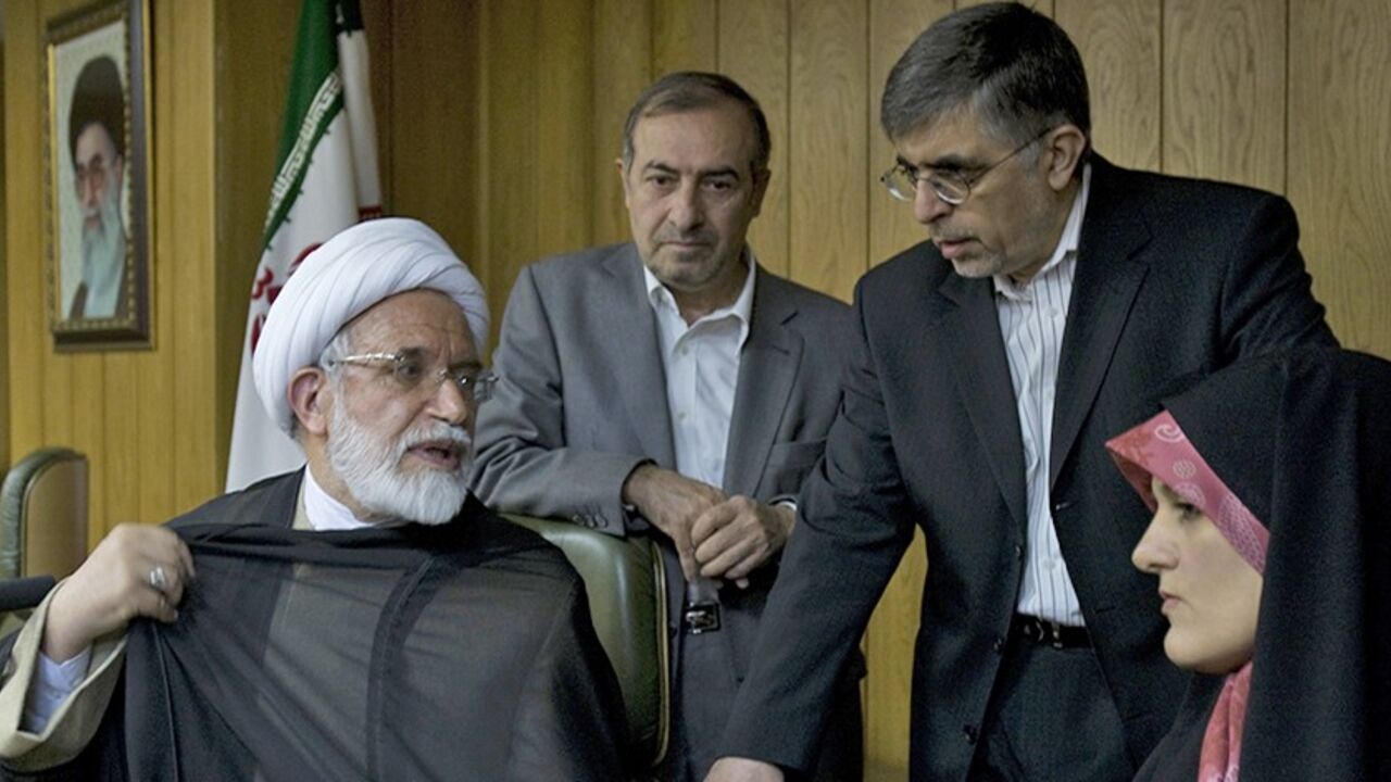 Iranian presidential candidate Mehdi Karoubi adjusts his clerical cloak as he speaks with advisors Morteza Alviri (2nd L), Gholamhossein Karbaschi and Jamileh Kadivar (R) before a news conference in Tehran June 9, 2009. Iranians vote in a presidential election on June 12.  REUTERS/Raheb Homavandi (IRAN POLITICS ELECTIONS) - RTR24H26