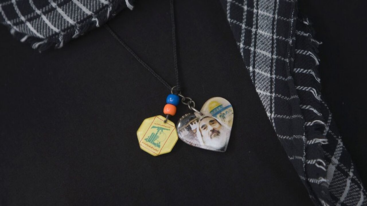 A demonstrator wears a Palestinian scarf and symbols with pictures of Lebanon's Hezbollah logo (L) and former Hamas Leader Sheikh Ahmed Yassin as he waits to attend a rally to mark al-Quds (Jerusalem) day in Istanbul September 18, 2009. REUTERS/Morteza Nikoubazl (TURKEY ANNIVERSARY POLITICS) - RTR2807G