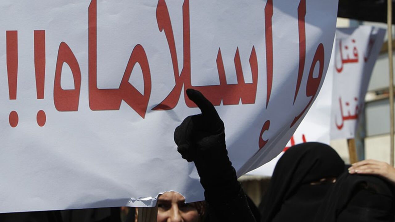 Members of Islamist Sunni group Jamaat al-Islamiya carry placards as they shout slogans against Syria's President Bashar al-Assad during an anti-government protest, at the port-city of Sidon in south Lebanon August 12, 2011. The placard reads "Oh Islam". REUTERS/Ali Hashisho (LEBANON - Tags: CIVIL UNREST POLITICS) - RTR2PV16