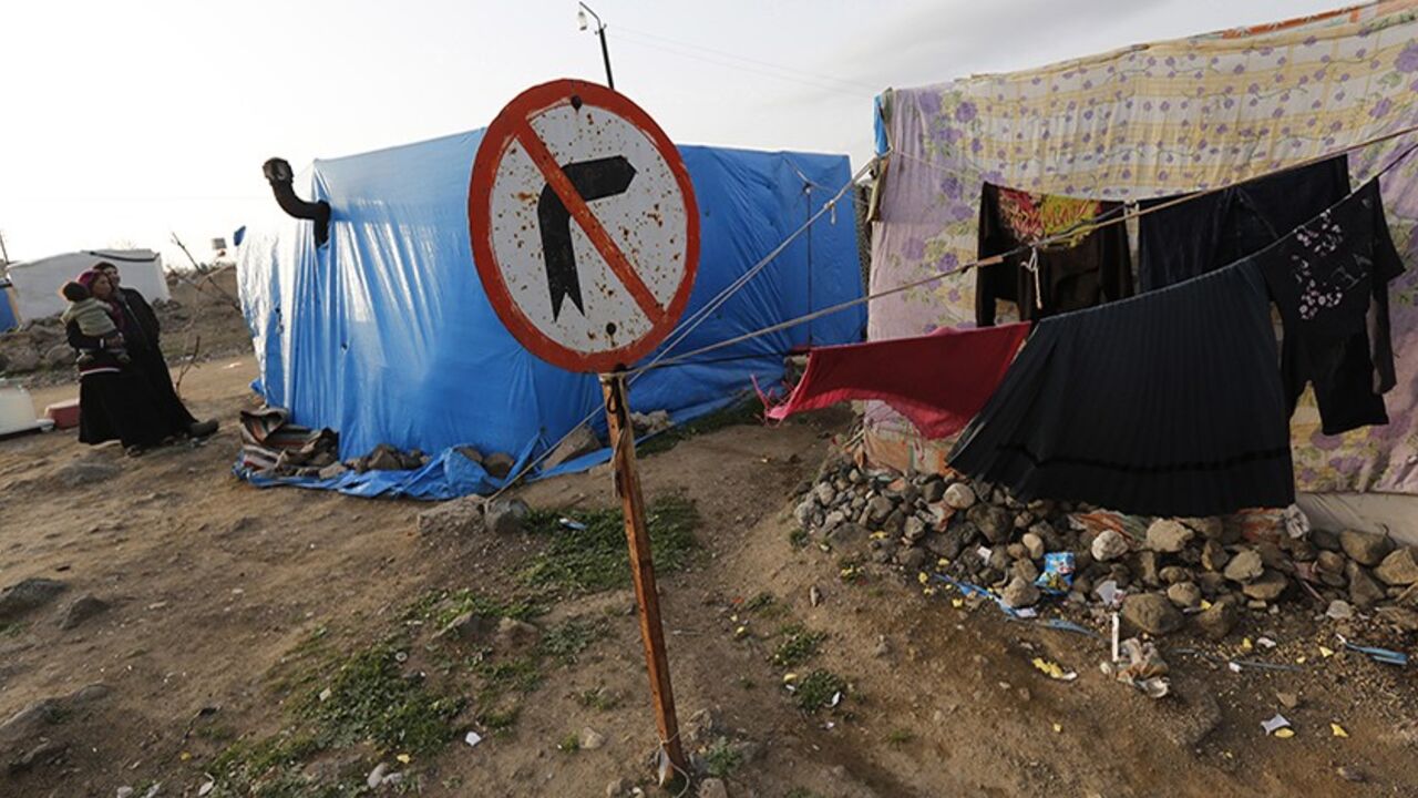 Syrian refugee women stand outside the tents where they took shelter with their families in Kilis on the Turkish-Syrian border March 17, 2014. Aleppo continues to bear the brunt of the civil war, in which about 140,000 people have died. Almost two years after rebels grabbed half of the city, they are now on the defensive, with government forces advancing on three sides. Turkey began building its refugee camps near the border in mid-2011, little knowing the war would last so long and bring such vast numbers 