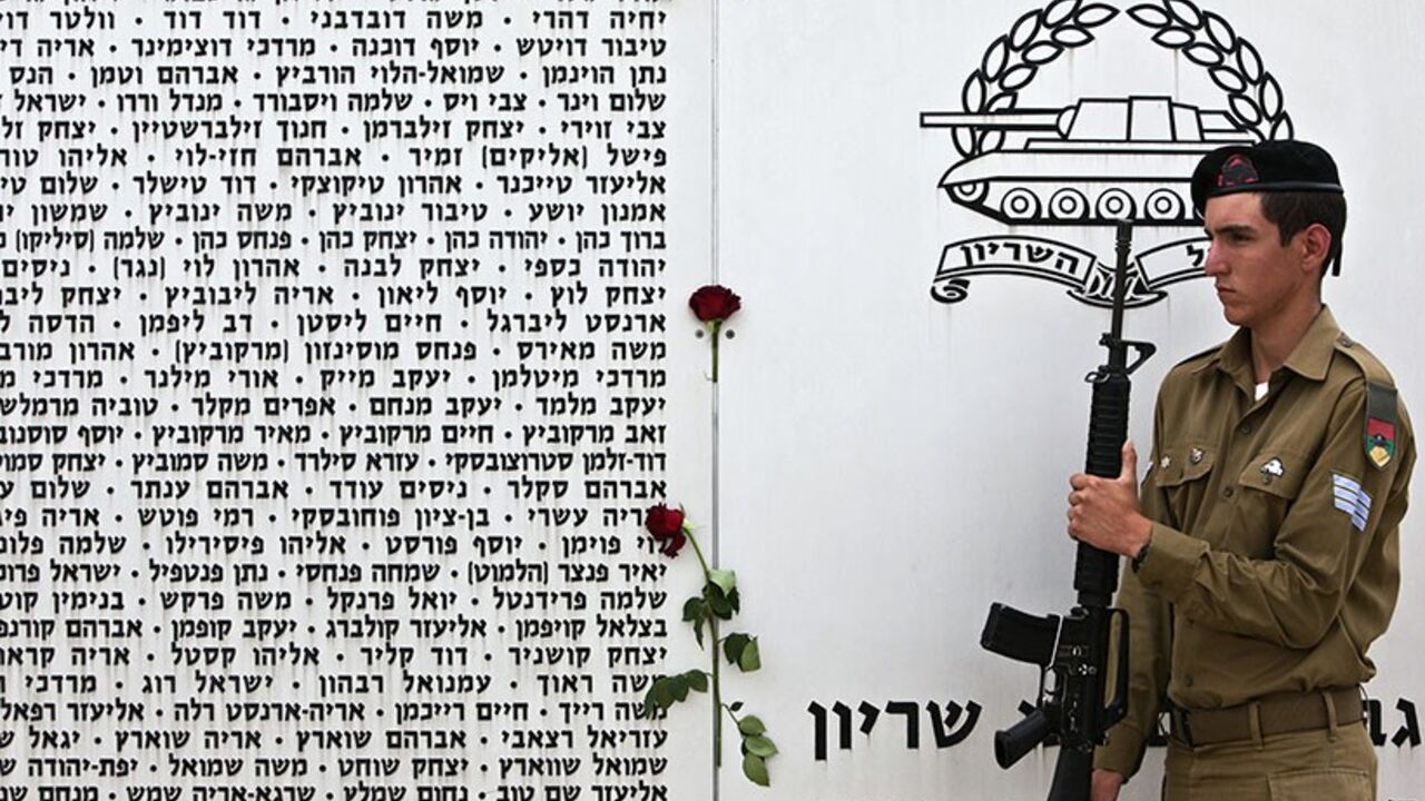 An Israeli soldier stands beside a memorial wall, engraved with names of fallen soldiers from the armoured corps, during a Memorial Day ceremony in Latrun near Jerusalem May 5, 2014.  Israel on Monday marks Memorial Day to commemorate its fallen soldiers. REUTERS/Nir Elias (ISRAEL - Tags: ANNIVERSARY MILITARY) - RTR3NTG1