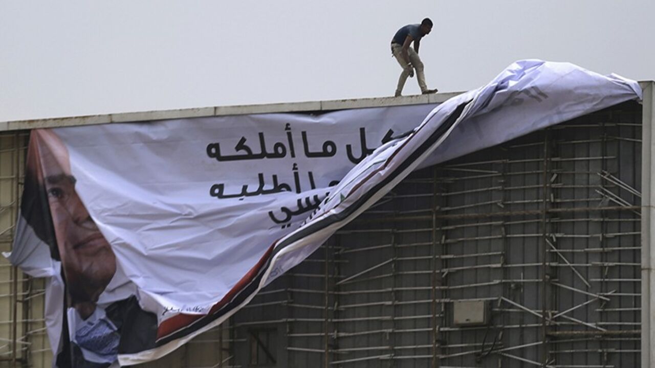 A worker stands and works on a campaign billboard of presidential candidate and Egypt's former army chief Abdel Fattah al-Sisi, along a highway in Cairo May 12, 2014. An influential Qatar-based Islamist whose fiery sermons have caused tension between Gulf states said on Sunday that Egyptian presidential front runner Abdel Fattah al-Sisi will only bring downfall to the country. Sisi is expected to easily win the May 26-27 presidential election. The only other candidate is leftist politician Hamdeen Sabahi, w