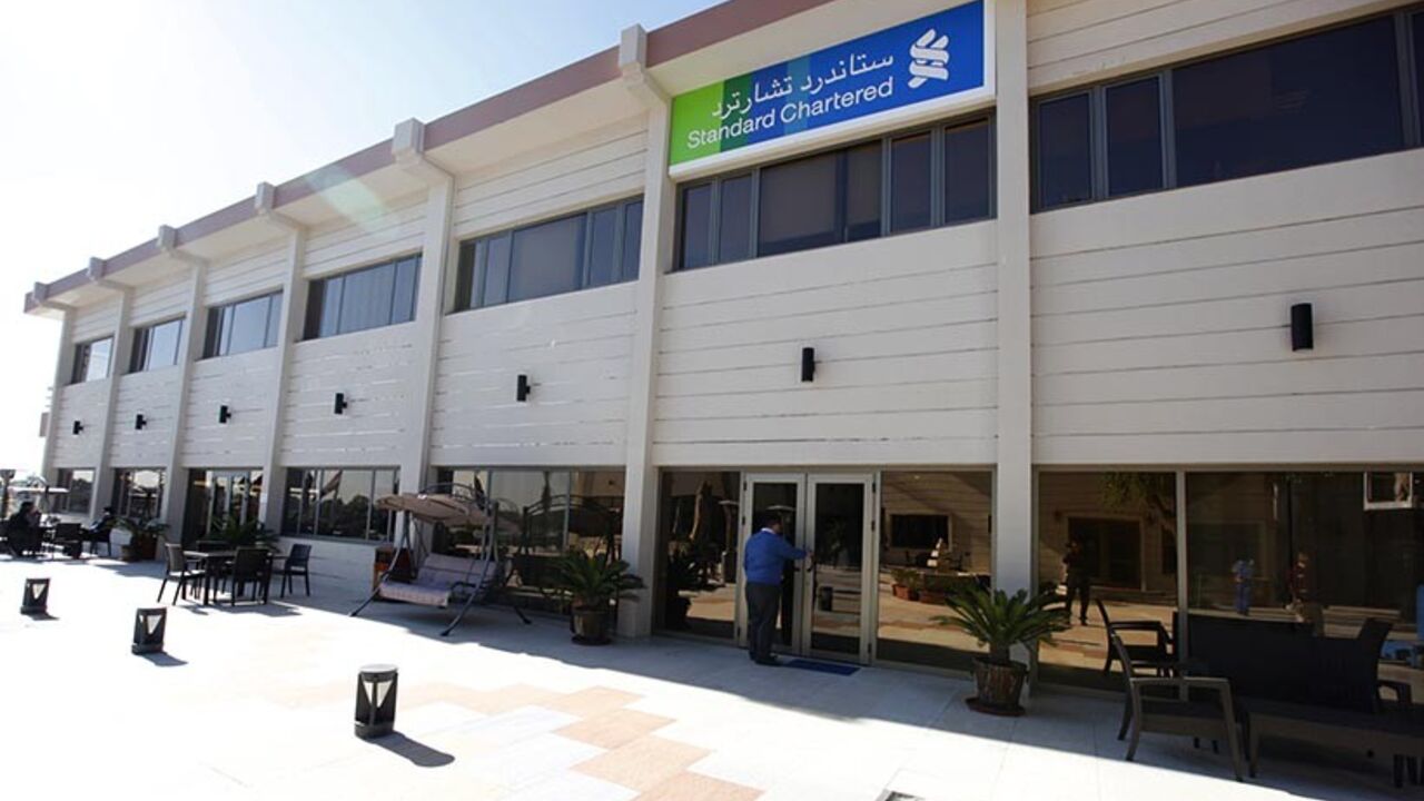 An employee of the Standard Chartered bank enters the bank in Baghdad, December 1, 2013. British lender Standard Chartered  launched banking operations in Iraq on Wednesday, saying it hoped to benefit from large infrastructure projects in a country trying to rebuild after years of conflict.  REUTERS/Ahmed Saad    (IRAQ - Tags - Tags: BUSINESS) - RTX15ZHF