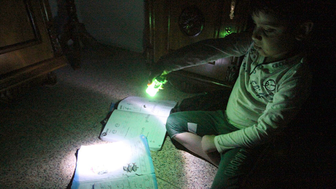TO GO WITH AFP STORY BY SALAM FARAJ
An Iraqi boy uses the light at the end of a lighter to study during a power outage in Baghdad on March 19, 2014. As recently as the 1970s, the Iraqi capital was lauded as a model city in the Arab world, but now, after decades of seemingly endless conflict, it is the world's worst city according to the latest survey by the Mercer consulting group. AFP PHOTO/ALI AL-SAADI        (Photo credit should read ALI AL-SAADI/AFP/Getty Images)