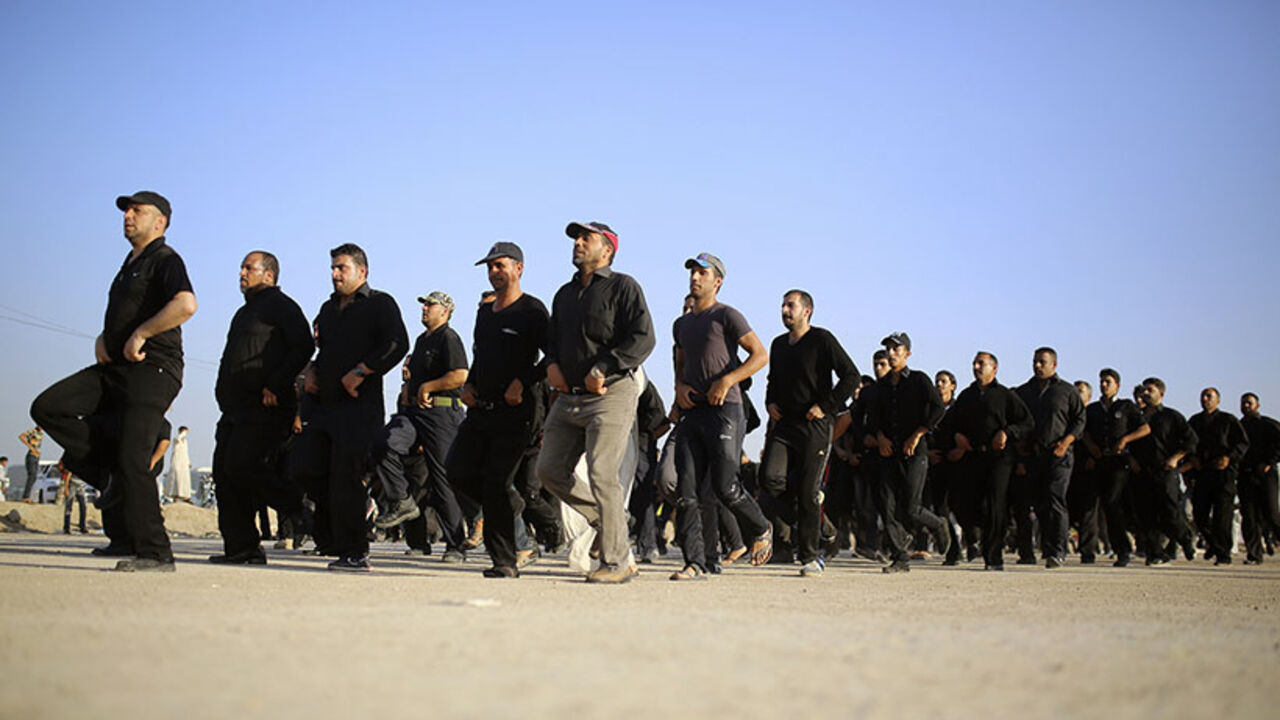 Mehdi Army fighters loyal to Shi'ite cleric Moqtada al-Sadr march during a military-style training in the holy city of Najaf, June 16, 2014. The United States said it could launch air strikes and act jointly with its arch-enemy Iran to support the Iraqi government, after a rampage by Sunni Islamist insurgents across Iraq that has scrambled alliances in the Middle East. REUTERS/Ahmad Mousa (IRAQ - Tags: CIVIL UNREST POLITICS) - RTR3U41A