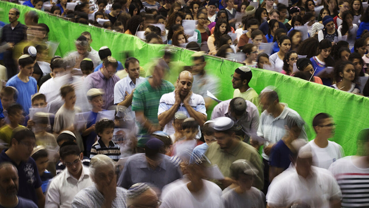 Israeli men and women, separated by a green divider, pray in the town of Elad, home of Eyal Yifrach, one of three missing teenagers, June 16, 2014. Prime Minister Benjamin Netanyahu prepared Israel for a long drawn-out operation to find the three missing teenagers as troops expanded the search into a crackdown on the Islamist group accused of abducting them and arrested dozens of its officials. REUTERS/Finbarr O'Reilly (ISRAEL - Tags: RELIGION POLITICS CIVIL UNREST) - RTR3U421