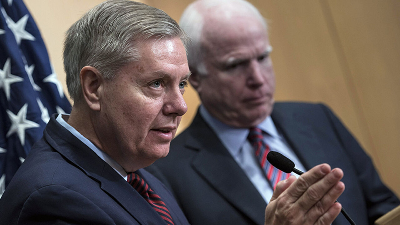 U.S. Senator Lindsey Graham (L) speaks near U.S. Republican Senator John McCain during a news conference at the David Citadel hotel in Jerusalem January 3, 2014.   REUTERS/Brendan Smialowski/Pool  (JERUSALEM - Tags: POLITICS) - RTX170Z3