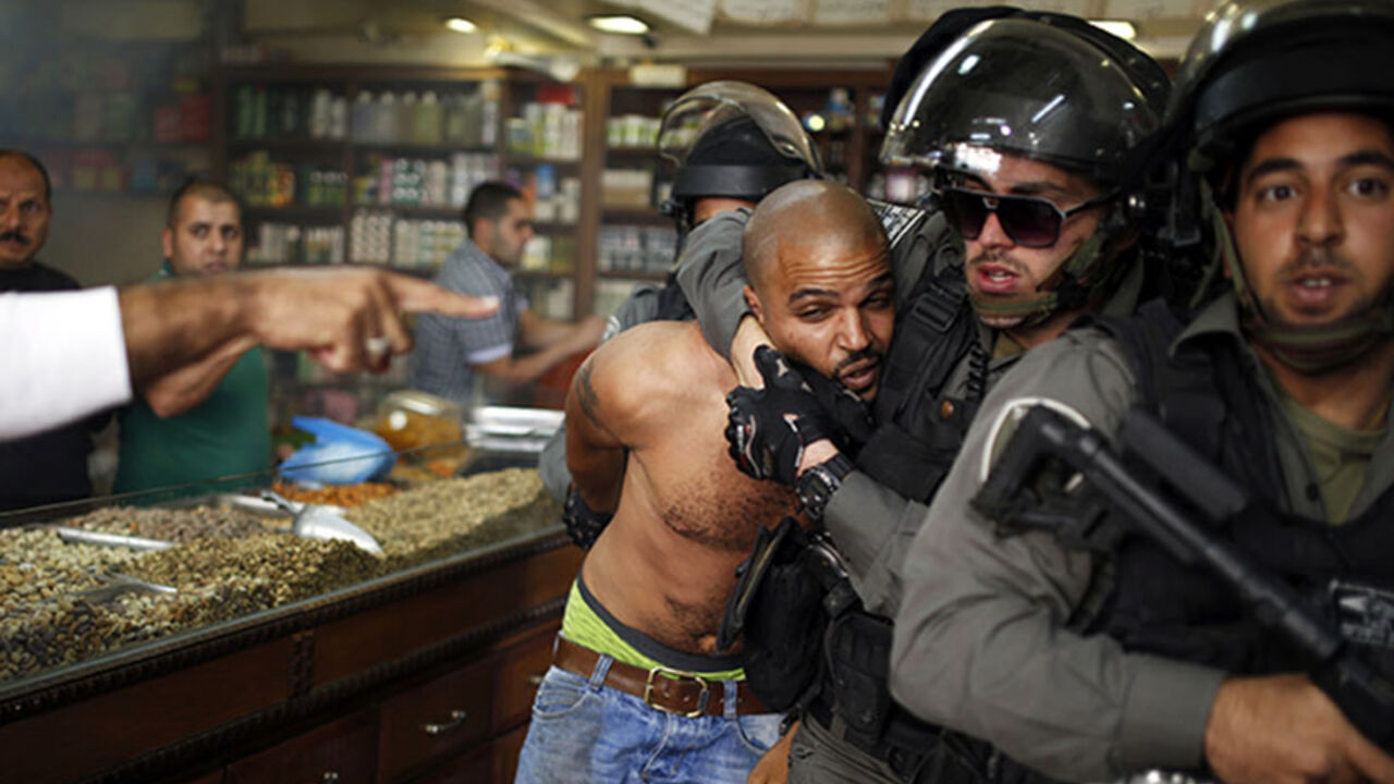 An Israeli border policeman detains a Palestinian protestor during clashes ahead of Land Day in east Jerusalem March 29, 2014. Land Day which is observed on Sunday in Israel commemorates the killing by security forces of six Arabs in 1976 during protests against government plans to confiscate land in northern Israel's Galilee region. REUTERS\Amir Cohen  (JERUSALEM - Tags: POLITICS CIVIL UNREST TPX IMAGES OF THE DAY) - RTR3J44S
