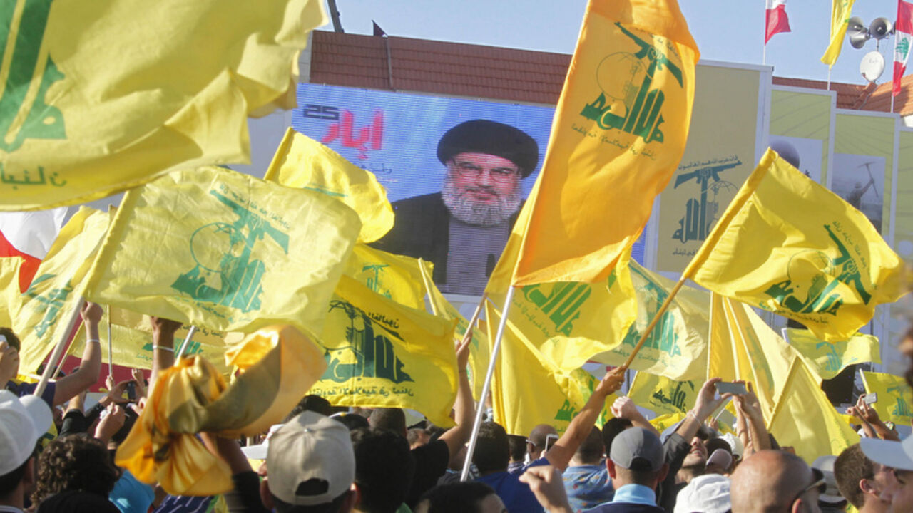 Residents watch Hezbollah leader Sayyed Hassan Nasrallah on a screen during his televised speech at a festival celebrating Resistance and Liberation Day, in Bint Jbeil May 25, 2014. The event commemorates the 14th anniversary of Israel's withdrawal from southern Lebanon.   REUTERS/Sharif Karim (LEBANON - Tags: POLITICS ANNIVERSARY) - RTR3QT8E
