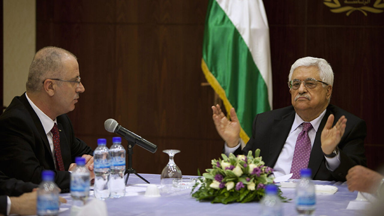 Palestinian President Mahmoud Abbas (R) meets with Palestinian Prime Minister Rami Hamdallah and ministers of the unity government, in the West Bank city of Ramallah June 2, 2014. Abbas swore in a Palestinian unity government on Monday under a reconciliation deal with Hamas Islamists that led Israel to freeze U.S.-brokered peace talks with the Western-backed leader. REUTERS/Majdi Mohammed/Pool (WEST BANK - Tags: POLITICS) - RTR3RU64