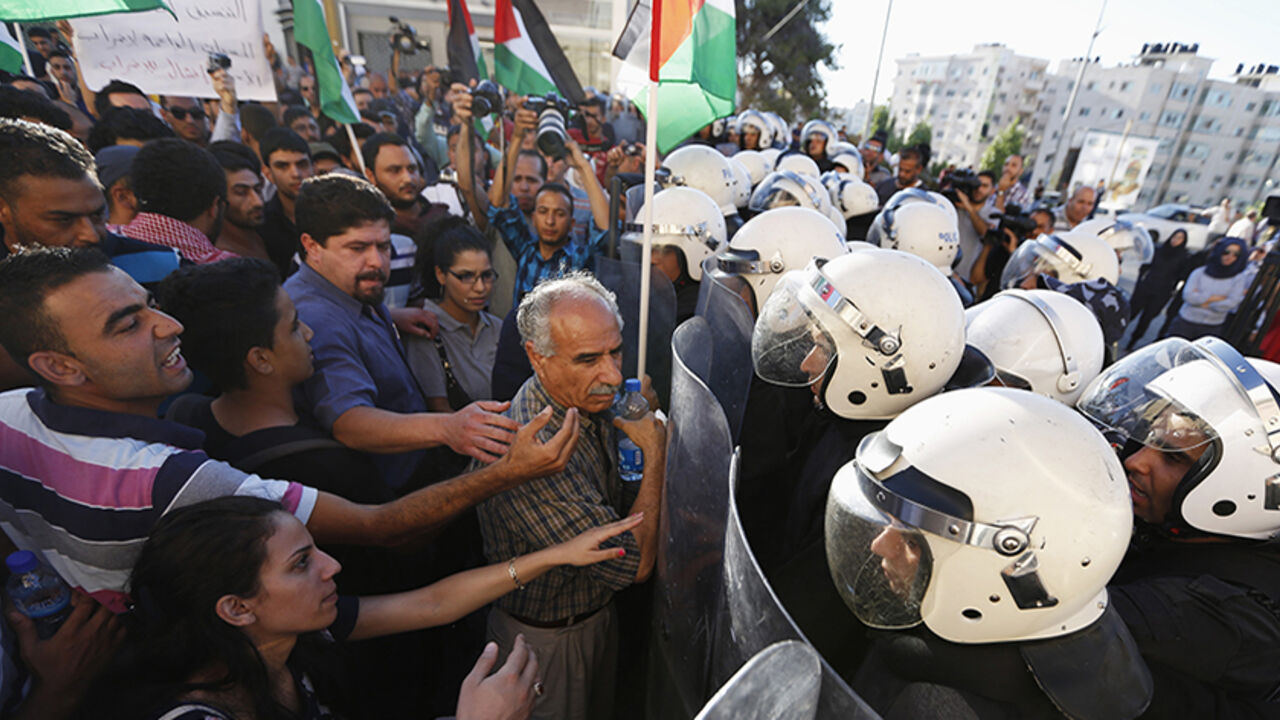 Protesters argue with Palestinian riot police during a protest against security coordination between Palestinian authority and Israel, in the West Bank city of Ramallah June 23, 2014. Israeli troops killed two Palestinians on Sunday, Palestinian medics and a militant group said, as Israel pressed on with its crackdown on Hamas, the Islamist group it accuses of abducting three Israeli teenagers. Palestinian president Mahmoud Abbas has condemned the abduction of the three Israelis, and his security forces hav