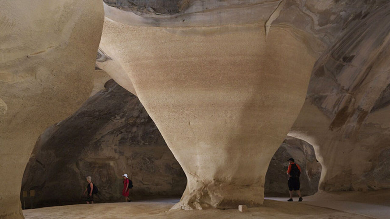 Visitors walk inside a cave situated below the ancient towns of Maresha and Beit Guvrin in the Judean Lowlands June 24, 2014. UNESCO designated the caves of Maresha and Beit Guvrin as a world heritage site on Sunday. The site features expansive man-made ancient tunnel systems, some dating back as early as the first century BC. REUTERS/Finbarr O'Reilly (ISRAEL - Tags: ENVIRONMENT SOCIETY TRAVEL) - RTR3VIXK