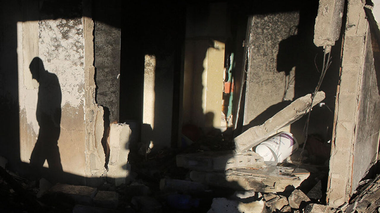 The shadow of a Palestinian man is cast as he inspects the family home of an alleged abductor after Israeli troops set off an explosion on the top floor in the West Bank City of Hebron July 1, 2014. The bodies of three missing Israeli teenagers were found in the occupied West Bank, and Israel vowed to punish Hamas, the Palestinian group it accuses of abducting and killing them. Troops set off explosions in the family homes of the alleged abductors, blowing open a doorway in one, an army spokeswoman said, wh