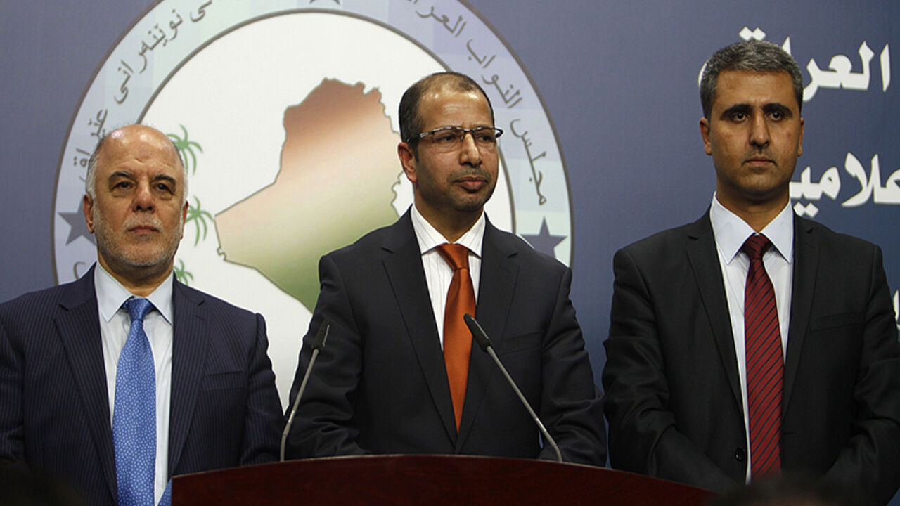 Iraqi newly elected parliament speaker Salim al-Juburi (C) stands between his deputies Haidar Al Abadi (L) and Aram Sheikh Mohamad (R) in Baghdad on July 15, 2014. Iraq's fractious parliament elected a speaker after two failed sittings, with al-Juburi winning comfortably according to a tally announced live on state television. The much-delayed election kickstarts a political process which should also see lawmakers agree on a federal president, who then designates the largest bloc, the candidate of which has