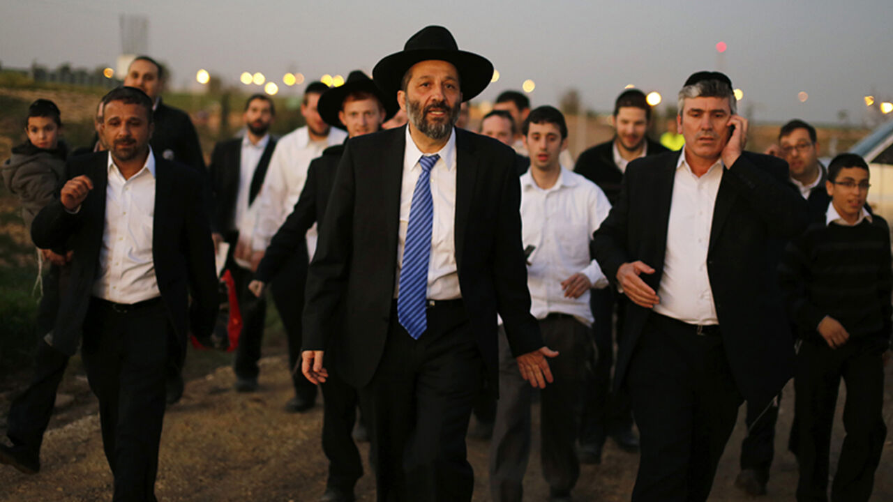 Aryeh Deri (C), leader of the ultra-Orthodox Shas party, attends an annual pilgrimage to the gravesite of Rabbi Yisrael Abuhatzeira, a Moroccan-born sage and kabbalist also known as the Baba Sali, in the southern town of Netivot January 14, 2013.  Powerful political players for years, Israel's ultra-Orthodox parties must now reckon with a new force ushered in by voters bent on stripping them of perks they have relied on for decades. Picture taken January 14, 2013. REUTERS/Amir Cohen (ISRAEL - Tags: POLITICS