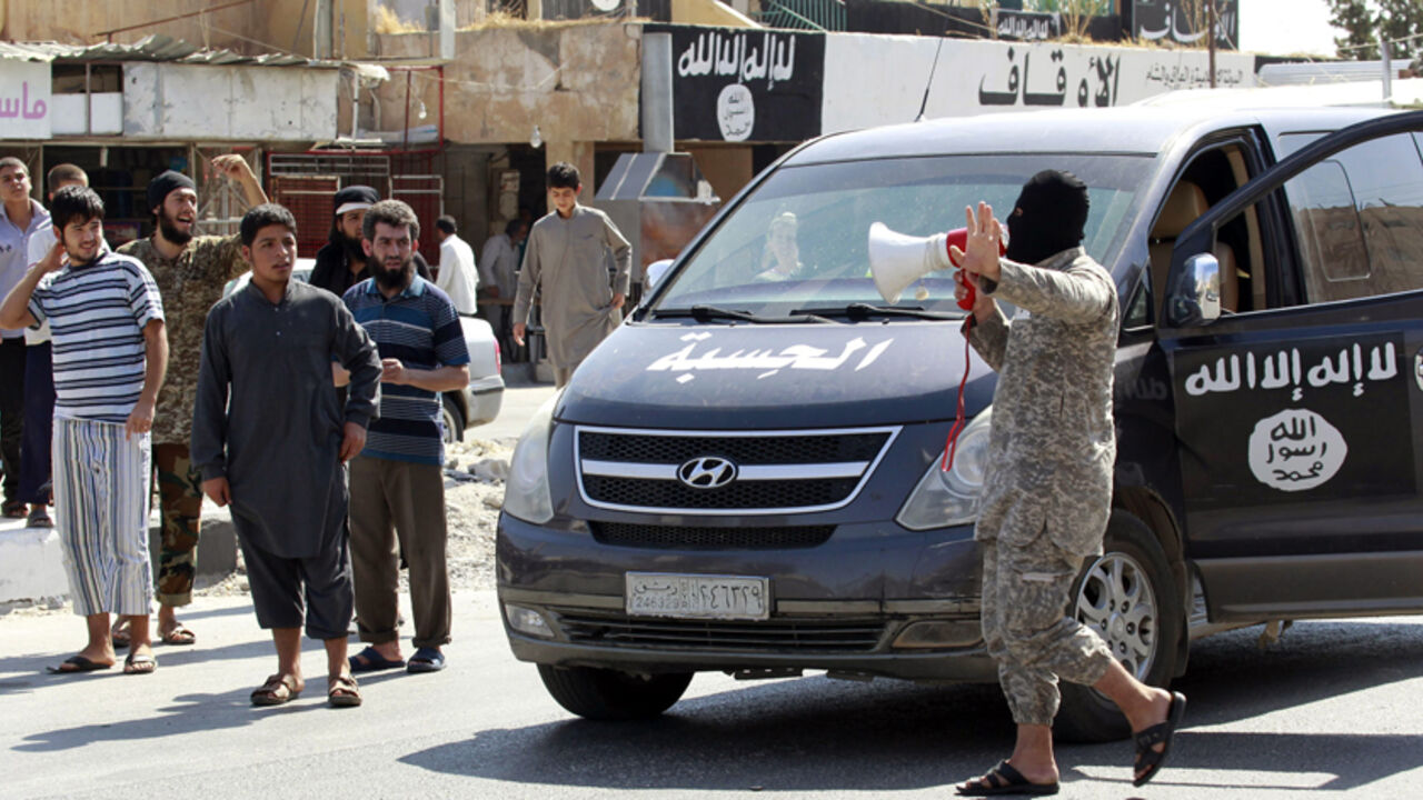 An Islamic State militant uses a loud-hailer to announce to residents of Tabqa city that Tabqa air base has fallen to Islamic State militants, in nearby Raqqa city August 24, 2014. Islamic State militants stormed the air base in northeast Syria on Sunday, capturing most of it from government forces after days of fighting over the strategic location, a witness and a monitoring group said. Fighting raged inside the walls of the Tabqa air base, the Syrian army's last foothold in an area otherwise controlled by
