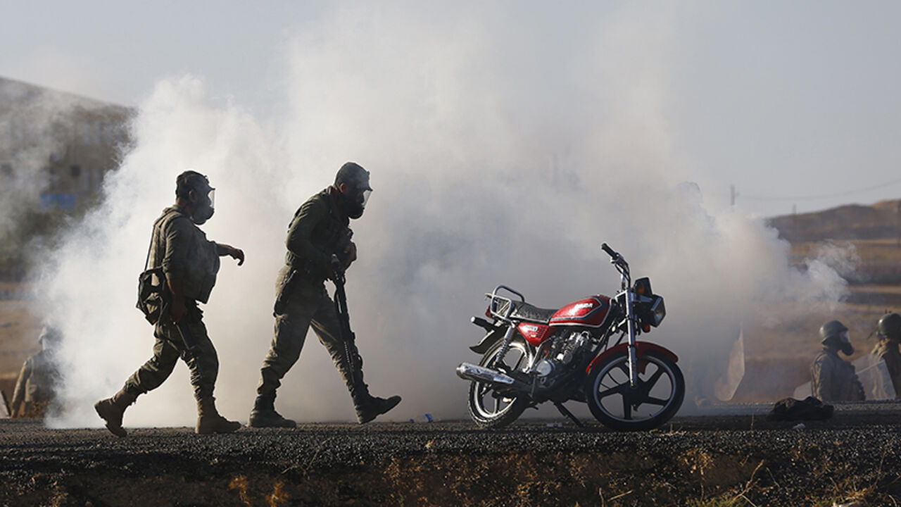 Turkish security forces use tear gas to disperse Turkish Kurds near the Mursitpinar border crossing on the Turkish-Syrian border, near the southeastern town of Suruc, September 26, 2014. Islamic State fighters tightened their siege of the strategic town of Kobani on Syria's border with Turkey on Friday, pushing back Kurdish forces and sending at least two shells into Turkish territory, witnesses said. Several hundred unarmed protesters who had gathered on the Turkish side of the border in solidarity with th