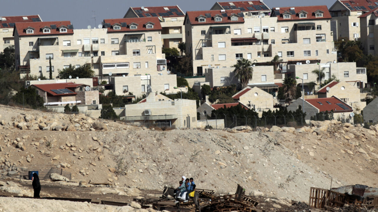 Palestinians ride on a donkey near homes in the West Bank Jewish settlement of Maale Adumim, near Jerusalem November 13, 2013. Palestinian President Mahmoud Abbas said on Wednesday his peace negotiators had resigned over the lack of progress in U.S.-brokered statehood talks clouded by Israeli settlement building. REUTERS/Ammar Awad (WEST BANK - Tags: POLITICS SOCIETY ANIMALS) - RTX15BNX