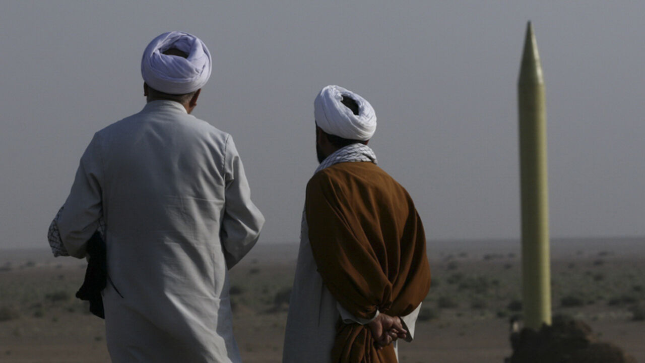 Two Iranian clerics stand near a surface to surface missile which is ready to be launched during a war game near the city of Qom, about 120 km (75 miles) south of Tehran June 28, 2011. REUTERS/Mehr News Agency/Rauf Mohseni (IRAN - Tags: POLITICS MILITARY RELIGION) QUALITY FROM SOURCE. FOR EDITORIAL USE ONLY. NOT FOR SALE FOR MARKETING OR ADVERTISING CAMPAIGNS. THIS IMAGE HAS BEEN SUPPLIED BY A THIRD PARTY. IT IS DISTRIBUTED, EXACTLY AS RECEIVED BY REUTERS, AS A SERVICE TO CLIENTS - RTR2O6NX