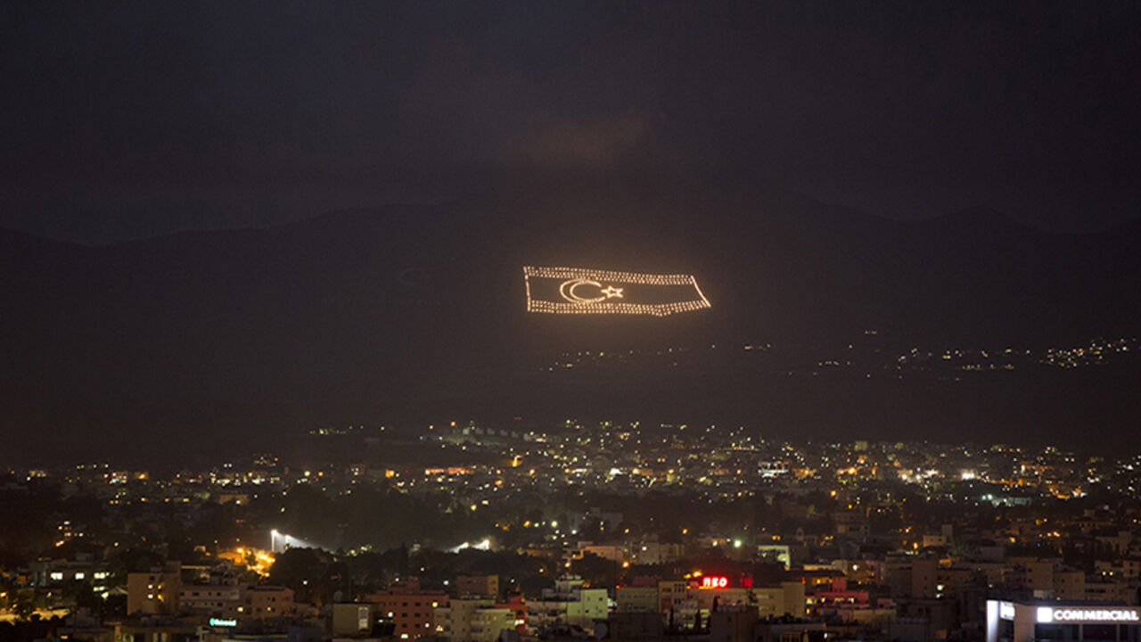 An illuminated flag of the self-declared Turkish Republic of Northern Cyprus, which is recognised only by Turkey, is seen overlooking Nicosia March 12, 2014. Greek and Turkish Cypriots have lived estranged for decades. A power-sharing government crumbled soon after independence from Britain in 1960 and the island has been divided since a Greek Cypriot coup was followed by a Turkish invasion of the north in 1974. Four decades on, a United Nations-controlled buffer zone splits Cyprus east to west, with Cyprus
