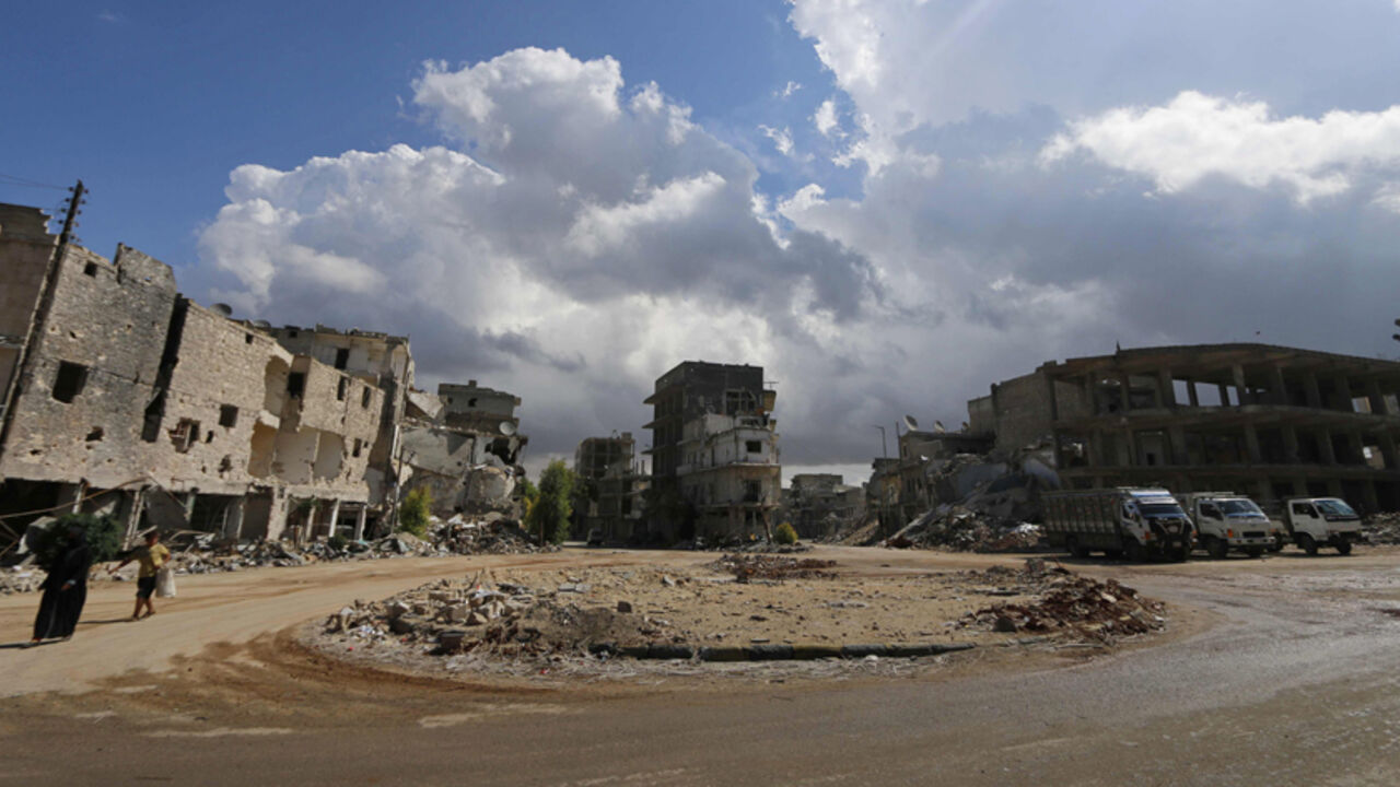 Civilians walk past damaged buildings in Aleppo's eastern district of Tariq al-Bab September 28, 2014. REUTERS/Hosam Katan (SYRIA - Tags: POLITICS CIVIL UNREST CONFLICT) - RTR481GO