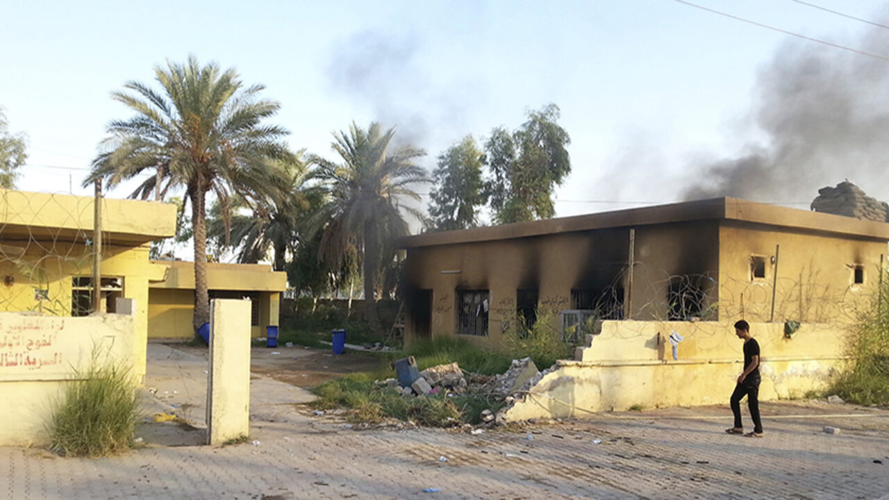 A man walks past a damaged building in the Anbar province town of Hit October 6, 2014. Iraqi forces backed by Shi'ite volunteer fighters are fighting to retake control of the western Iraqi town of Hit from the insurgents of the Islamic State, residents said. Residents said that fighting is going on in the outskirts of the town, which was captured by IS militants a week ago. Picture taken October 6. REUTERS/Stringer (IRAQ - Tags: CIVIL UNREST POLITICS MILITARY TPX IMAGES OF THE DAY) - RTR49ECK