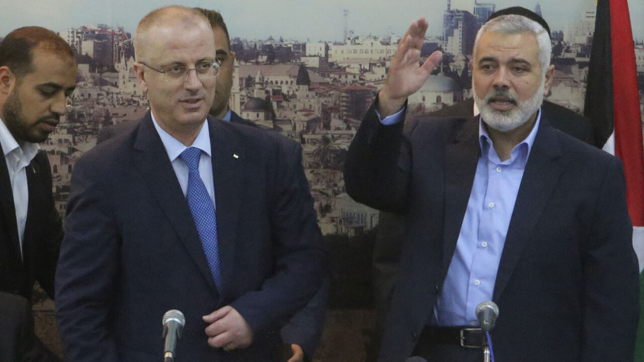 Senior Hamas leader Ismail Haniyeh (R) waves as he hosts Palestinian Prime Minister Rami Hamdallah at his house in Gaza City October 9, 2014. Hamdallah arrived in the Hamas-dominated Gaza Strip on Thursday and convened the first meeting of a unity government there since a brief civil war in 2007 between Hamas and forces loyal to the Fatah party.     REUTERS/Ibraheem Abu Mustafa (GAZA - Tags: POLITICS CIVIL UNREST) - RTR49J6C