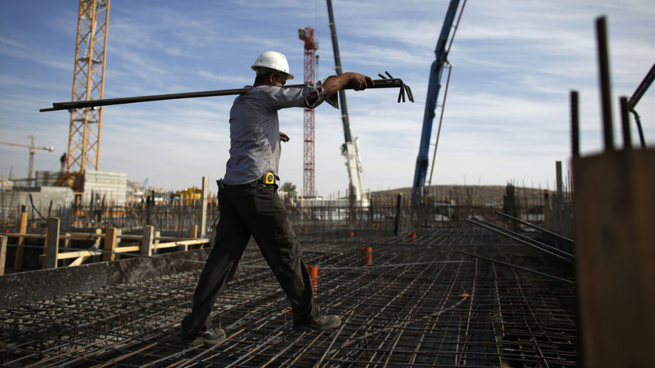 A labourer works on an apartment building under construction in a Jewish settlement known to Israelis as Har Homa and to Palestinians as Jabal Abu Ghneim in an area of the West Bank that Israel captured in a 1967 war and annexed to the city of Jerusalem, October 28, 2014. Israeli Prime Minister Benjamin Netanyahu will expedite planning for some 1,000 settler homes in East Jerusalem, a government official said on Monday, in a bid to placate a restive coalition ally without further aggravating a dispute with 
