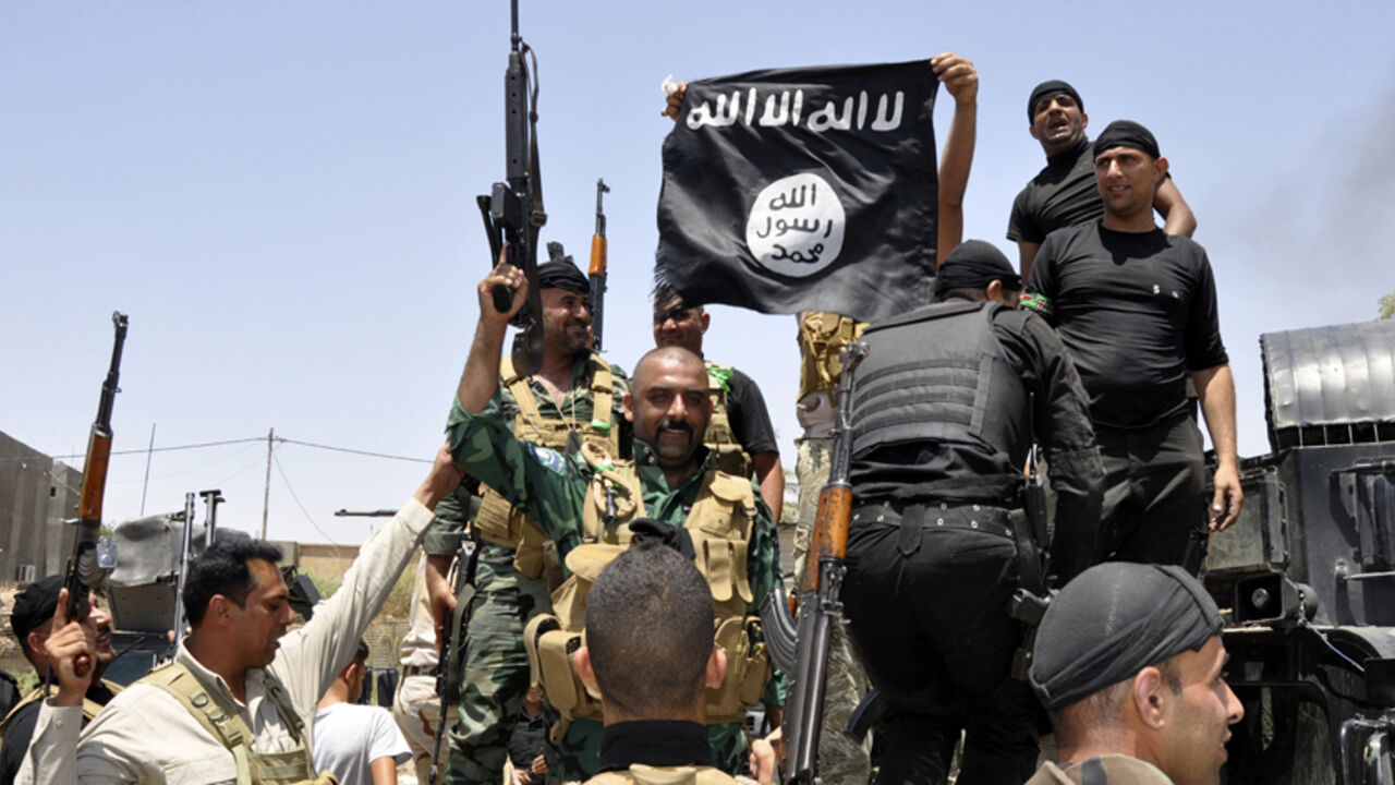 Iraqi security forces pull down a flag belonging to Sunni militant group Islamic State of Iraq and the Levant (ISIL) during a patrol in the town of Dalli Abbas in Diyala province, June 30, 2014. The leader of the al Qaeda offshoot now calling itself the Islamic State has called on Muslims worldwide to take up arms and flock to the "caliphate" it has declared on captured Syrian and Iraqi soil. Picture taken June 30, 2014. REUTERS/Stringer (IRAQ - Tags: CIVIL UNREST POLITICS MILITARY TPX IMAGES OF THE DAY) - 