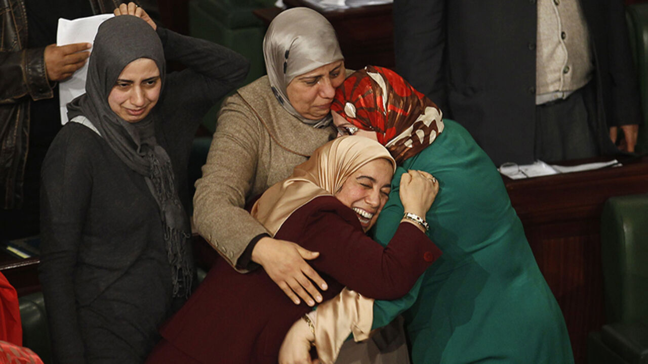 Members of the Tunisian parliament celebrate after approving the country's new constitution in the assembly building in Tunis January 26, 2014. Tunisia's national assembly approved the country's new constitution on Sunday in one of the final steps to full democracy three years after protests erupted into an uprising that toppled autocrat Zine el-Abidine Ben Ali. REUTERS/Zoubeir Souissi (TUNISIA - Tags: POLITICS TPX IMAGES OF THE DAY) - RTX17W7W