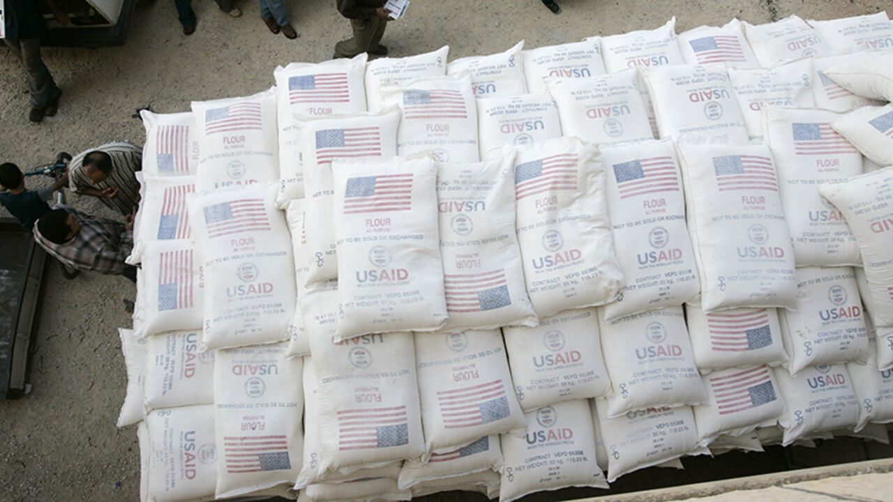 Palestinians stand beside a truck loaded with sacks of flour received from The United States Agency for International Development (USAID) in the village of Anin near the West Bank city of Jenin June 4, 2008.    REUTERS/Mohamad Torokman (WEST BANK) - RTX6I8P