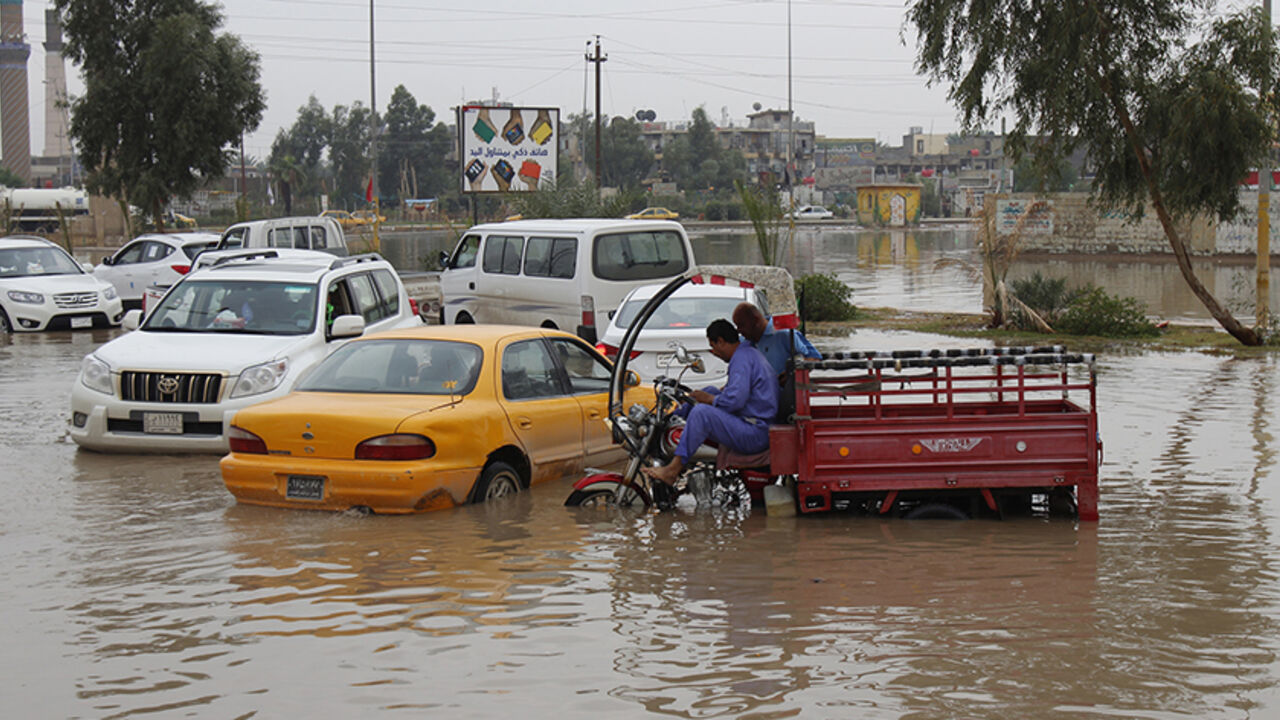 Vehicles are seen along a flooded street after heavy overnight rains in Baghdad, November 11, 2013. Baghdad's streets were knee deep in dirty water after heavy overnight rains. Residents struggle with the poor sewage system and lack of municipal services. REUTERS/Ahmed Saad  (IRAQ - Tags: ENVIRONMENT SOCIETY) ) - RTX1597K