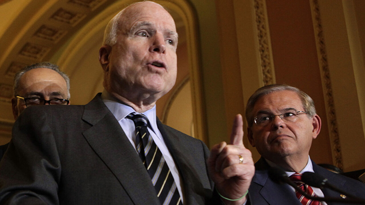 U.S. Senator John McCain (R-AZ) speaks to the media next to Senate Foreign Relations Committee Chairman Robert Menendez (D-NJ) after the Senate passed the immigration bill on Capitol Hill in Washington June 27, 2013. REUTERS/Yuri Gripas (UNITED STATES - Tags: POLITICS SOCIETY IMMIGRATION) - RTX11423