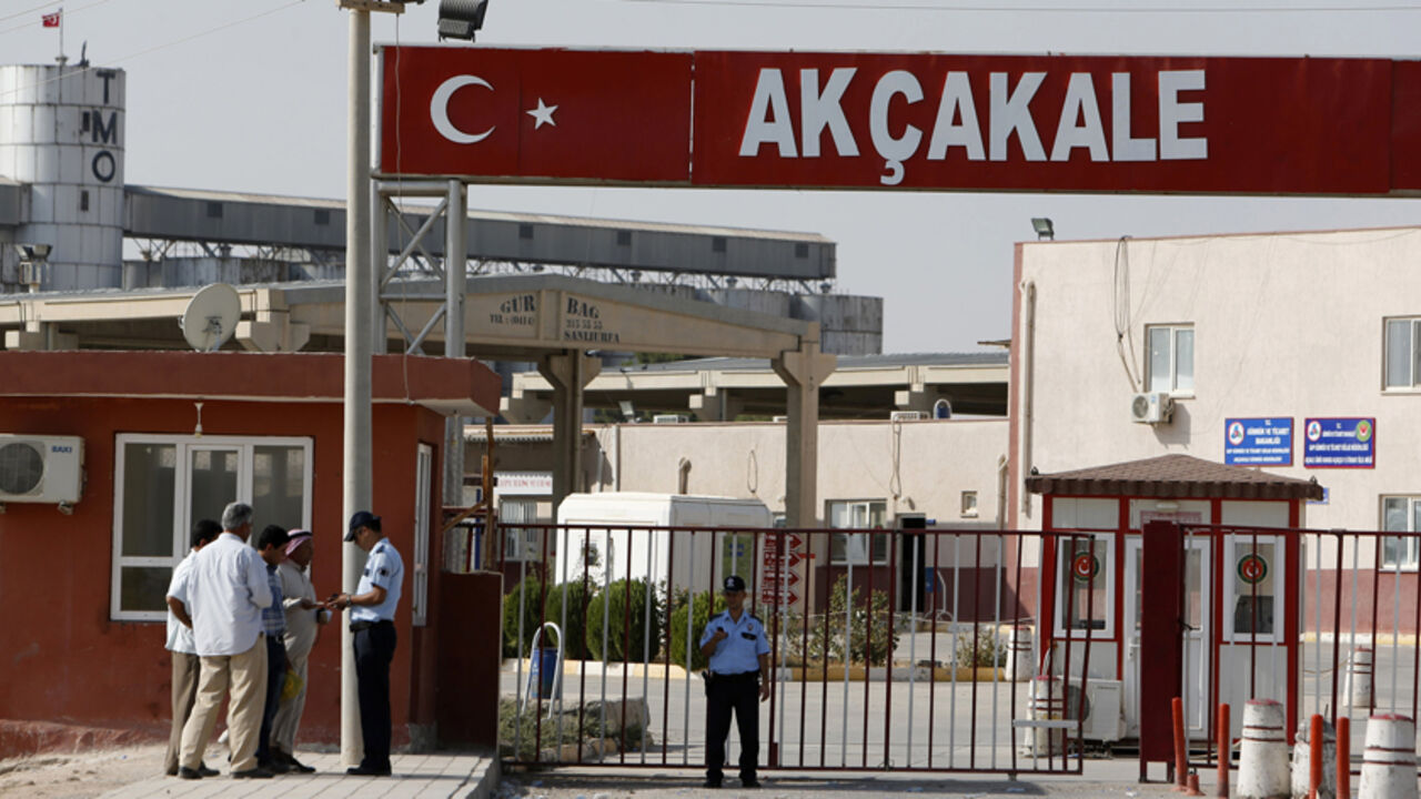 A Turkish police officer checks identification cards of Syrian men after they crossed from Syria to Turkey at the Akcakale border gate, southern Sanliurfa province, October 4, 2012. Turkish artillery hit targets near Syria's Tel Abyad border town for a second day on Thursday, killing several Syrian soldiers according to activists and security sources, after a mortar bomb fired from the area killed five Turkish civilians. Turkey's government said "aggressive action" against its territory by Syria's military 